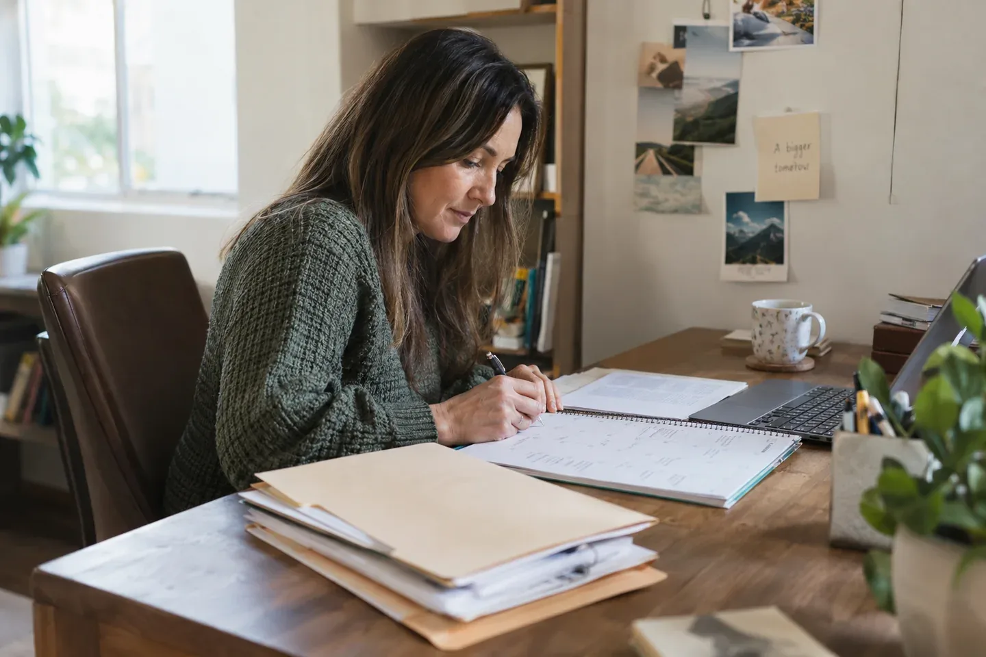 A woman planning appointments in a paper calendar beside document folders.