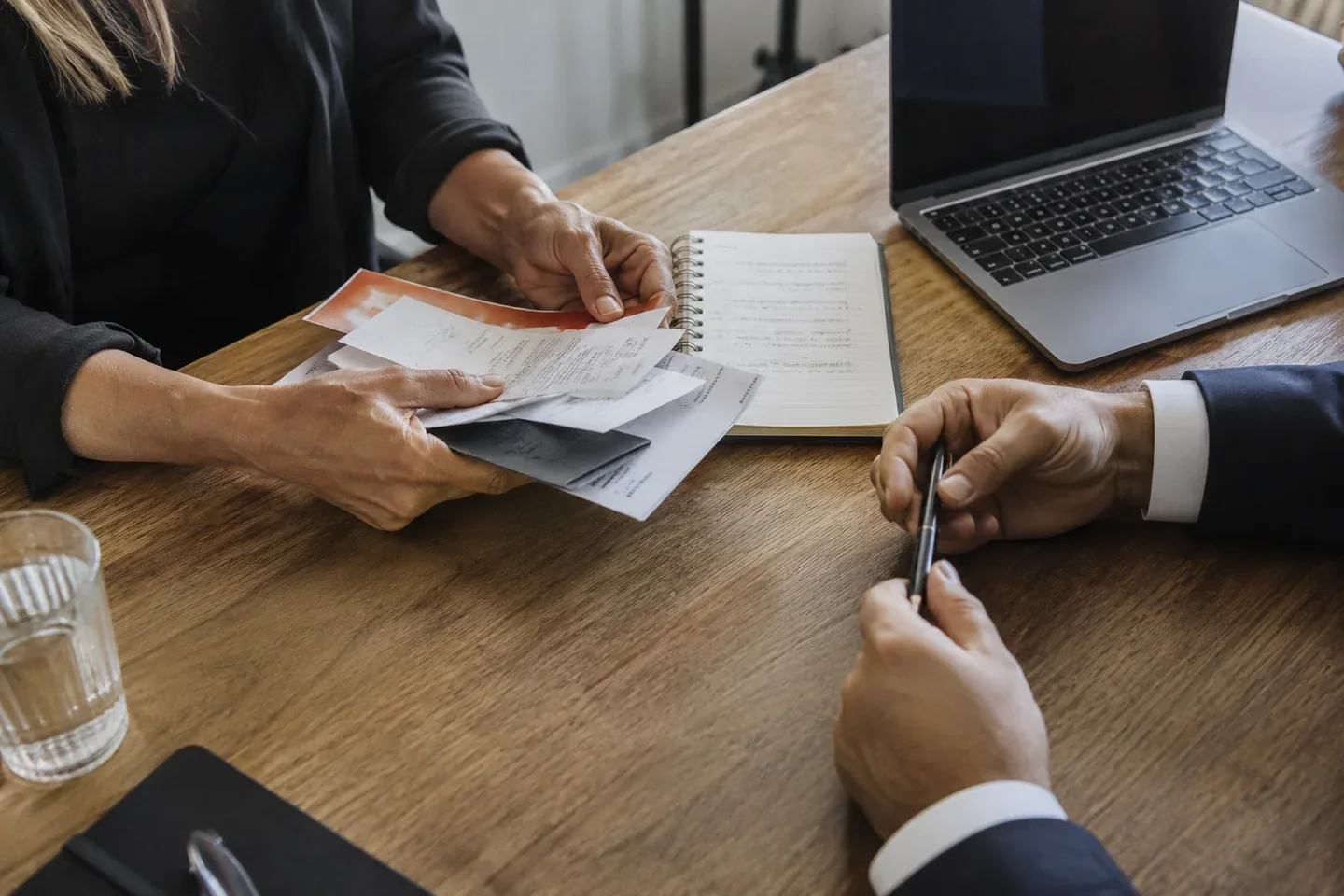 A document folder, receipts and notebook being reviewed at a consultation desk.